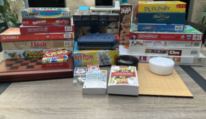 Various board games stacked on desk with books