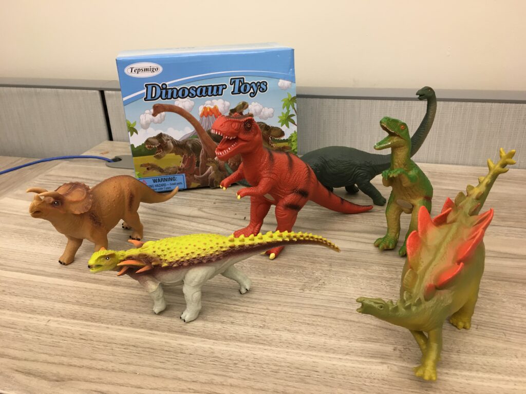 Various dinosaur toys on desk